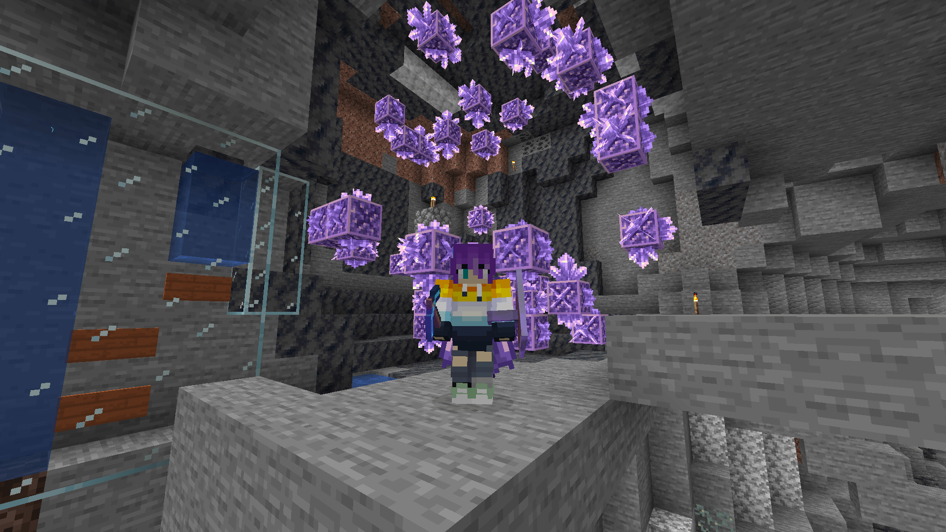 Crystals clear! A Minecraft player stands in front of a cluster of budding amethyst blocks and the bottom section of a bubble elevator.