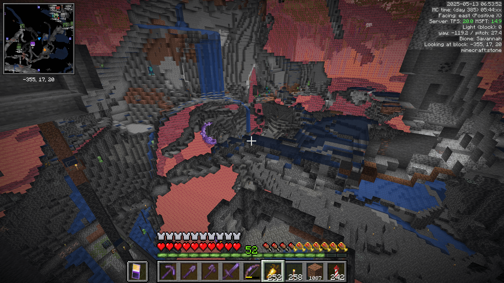 Freecam view of an underground area with a variety of caves. There is a large red wall in the background, indicating the edge of the despawn radius.