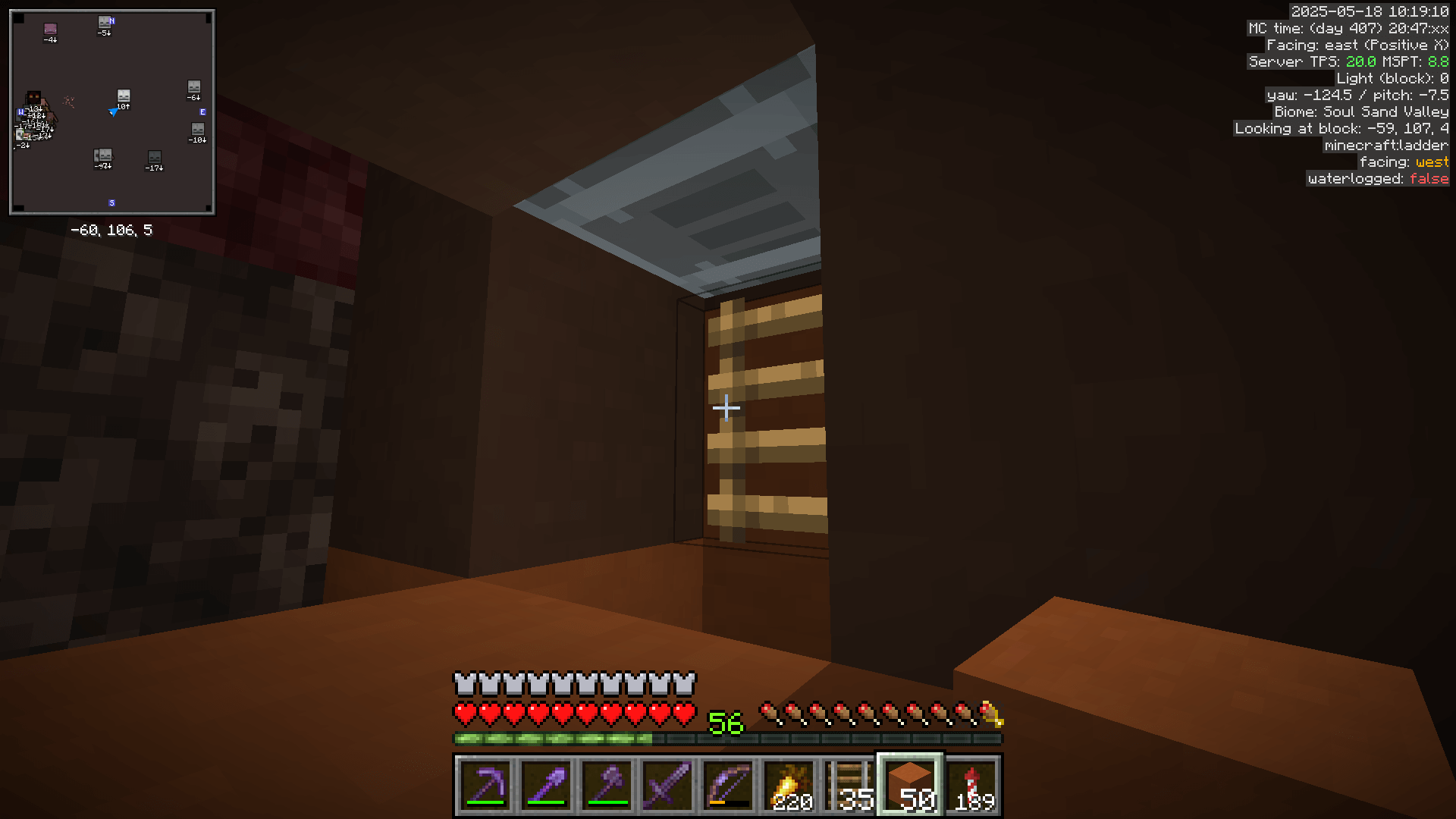 Installing an elevator minecart in an enclosed space within the ceiling of the nether. The bottom surface of the cart is visible as it rests on a ladder.