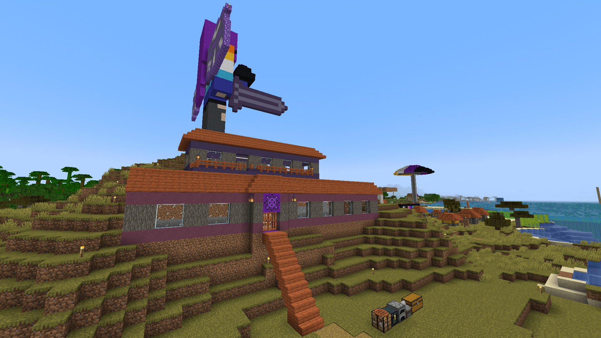 An acacia and terracotta house on a savanna hillside. A large statue of Ela looms over the building from behind.