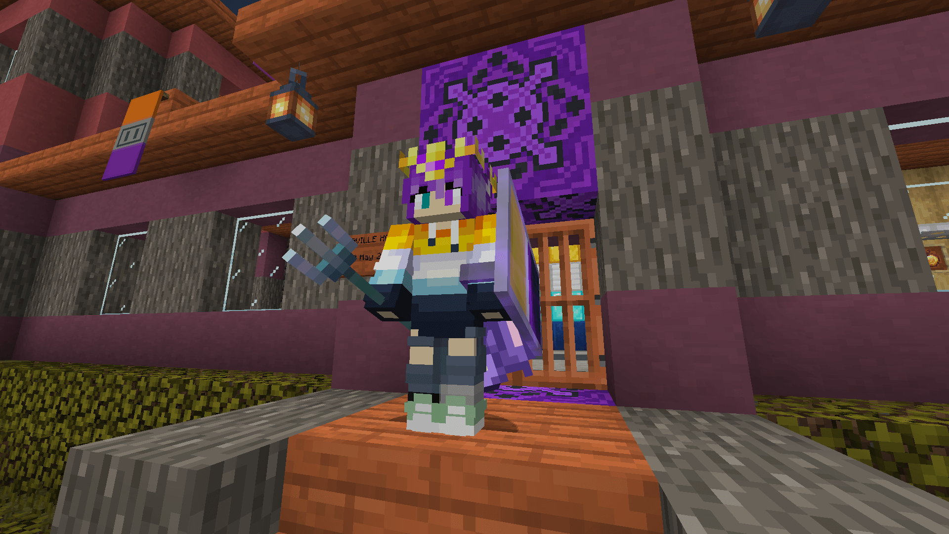 Ela stands at the doorstep of their house wearing a gold crown and wielding a trident.