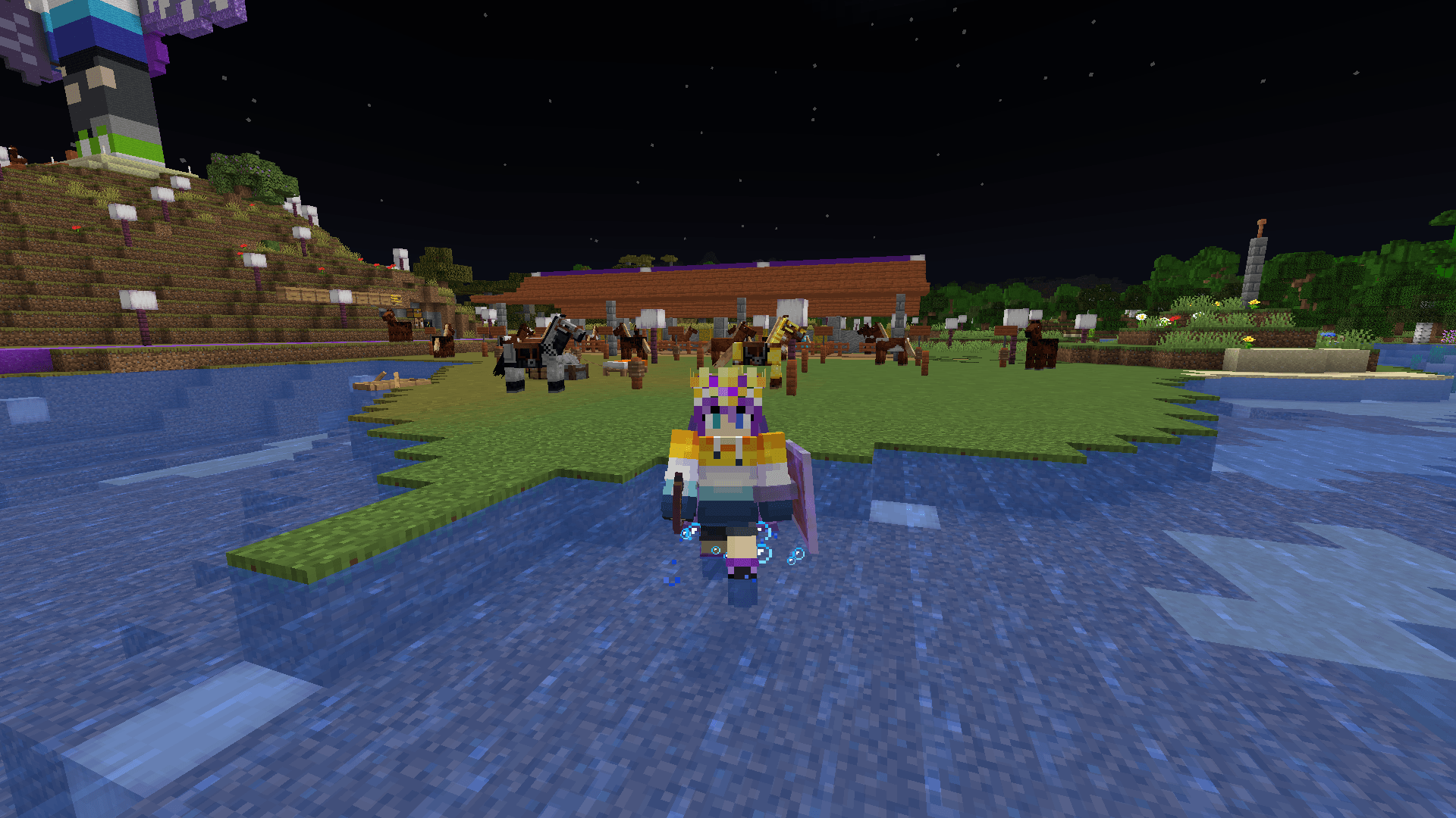 Ela splashes in a shallow section of river in front of a horse stable.