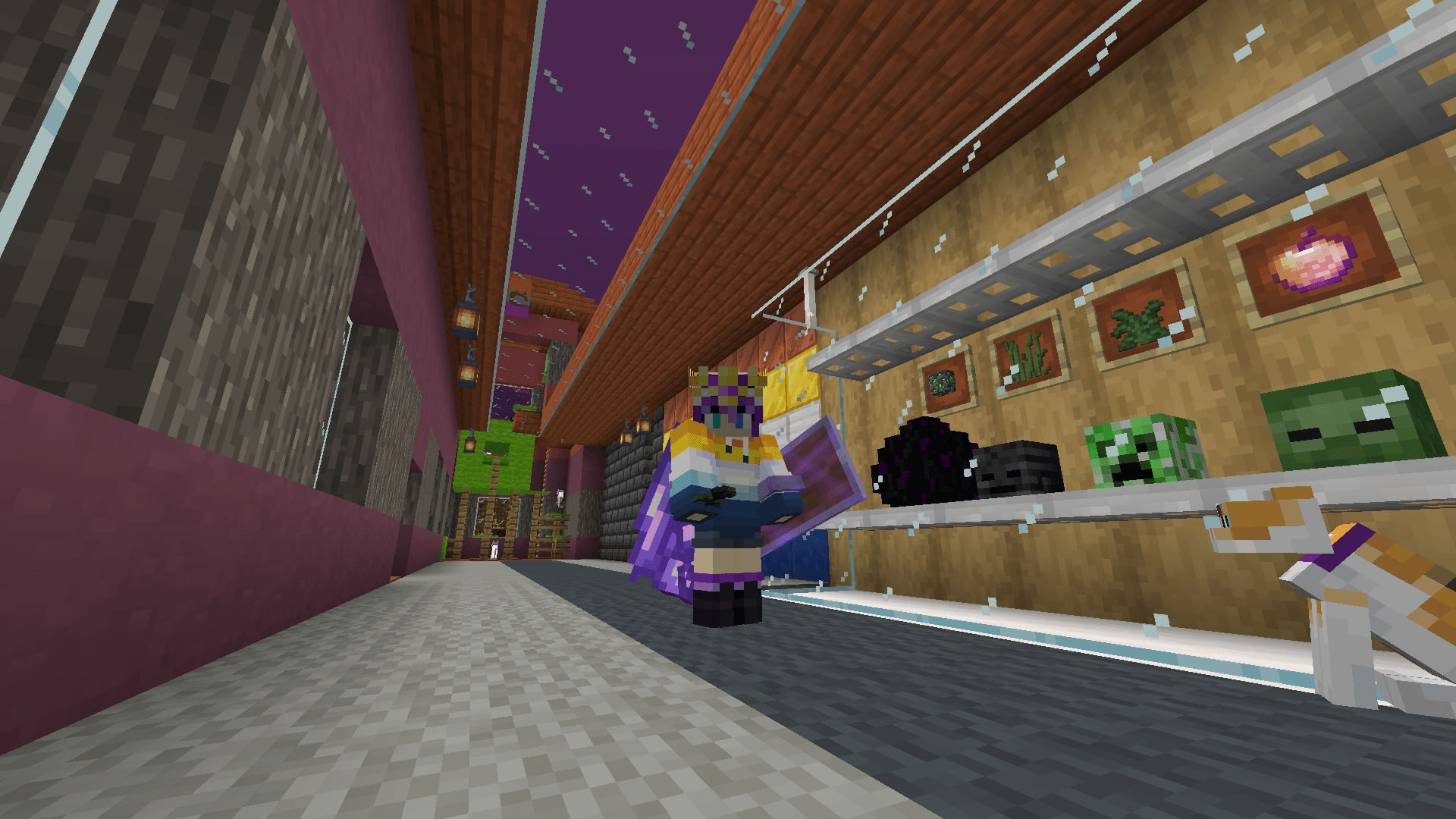 Ela stands in front of the trophy cabinet in their house, accompanied by a calico cat. It now contains a wither skeleton skull in addition to the other mob heads.
