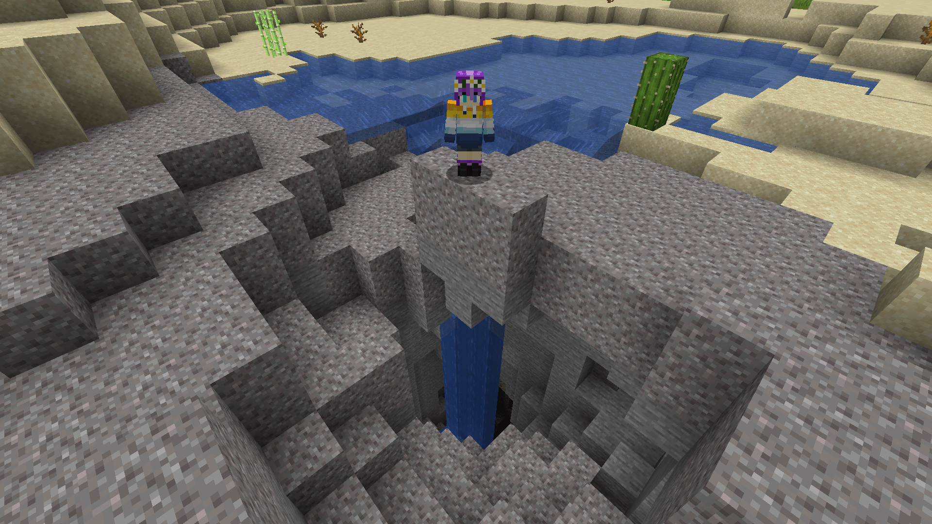 Ela stands over a gravel beach that has caved in, exposing a cave with water flowing into it.